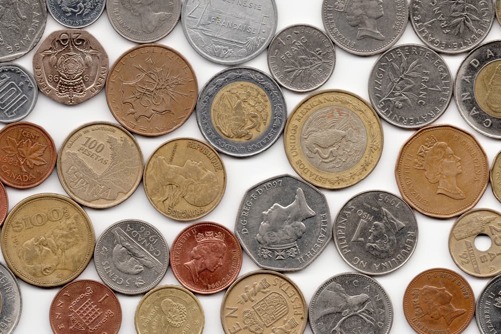 Coins from various countries on white background